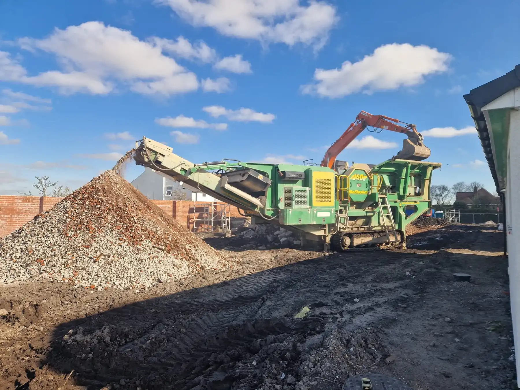 a green and yellow truck and some dirt and buildings